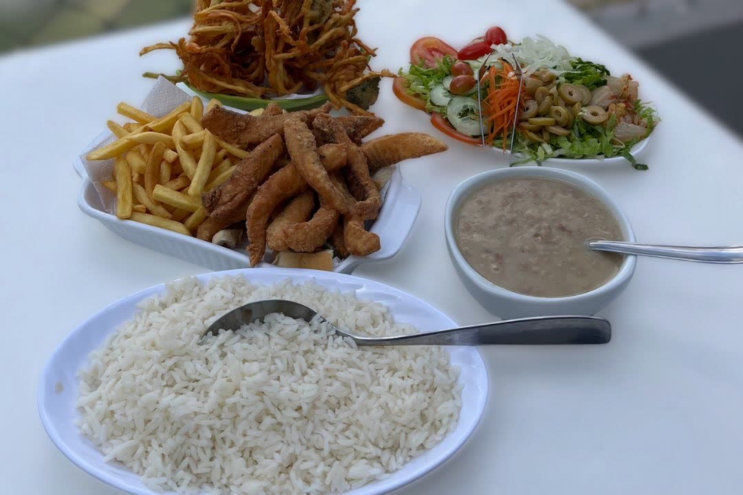 Porção de isca de tilápia com batata frita, arroz e salada