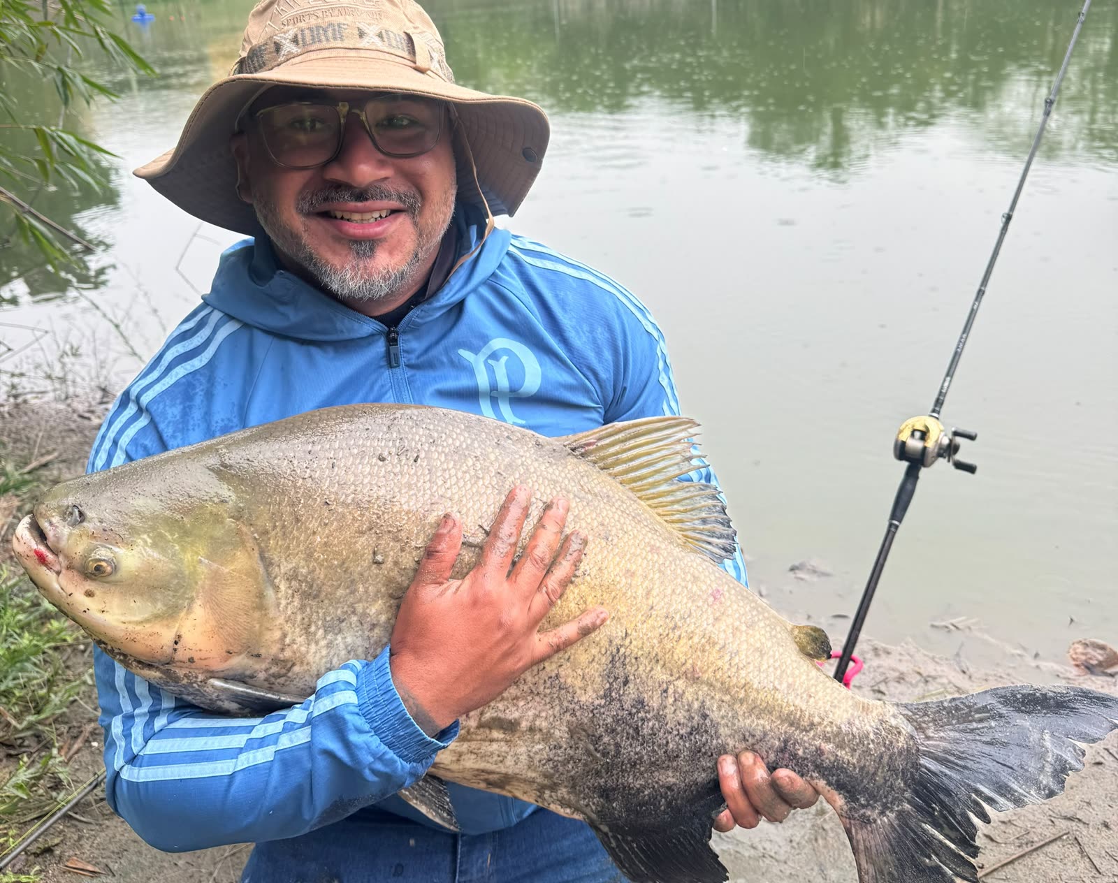 Pescador de chapéu segurando um tambacu